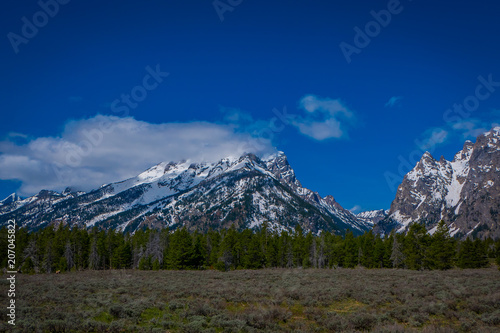 Beautiful landscape of the Grand Tetons range and peaks located inside the Grand Teton National Park, Wyoming, with house mountain covered with snow in the horizont