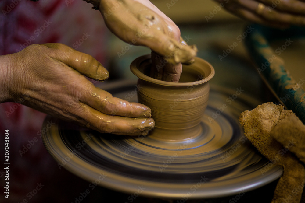 Sculpts in clay pot closeup. Modeling clay close-up. Caucasian man making vessel daytime of white clay in fast moving circle. Art, creativity. Ukraine, cultural traditions. Hobbies Sculpts in clay pot closeup. Modeling clay close-up. Caucasian man making vessel daytime of white clay in fast moving circle. Art, creativity. Ukraine, cultural traditions. Hobbies