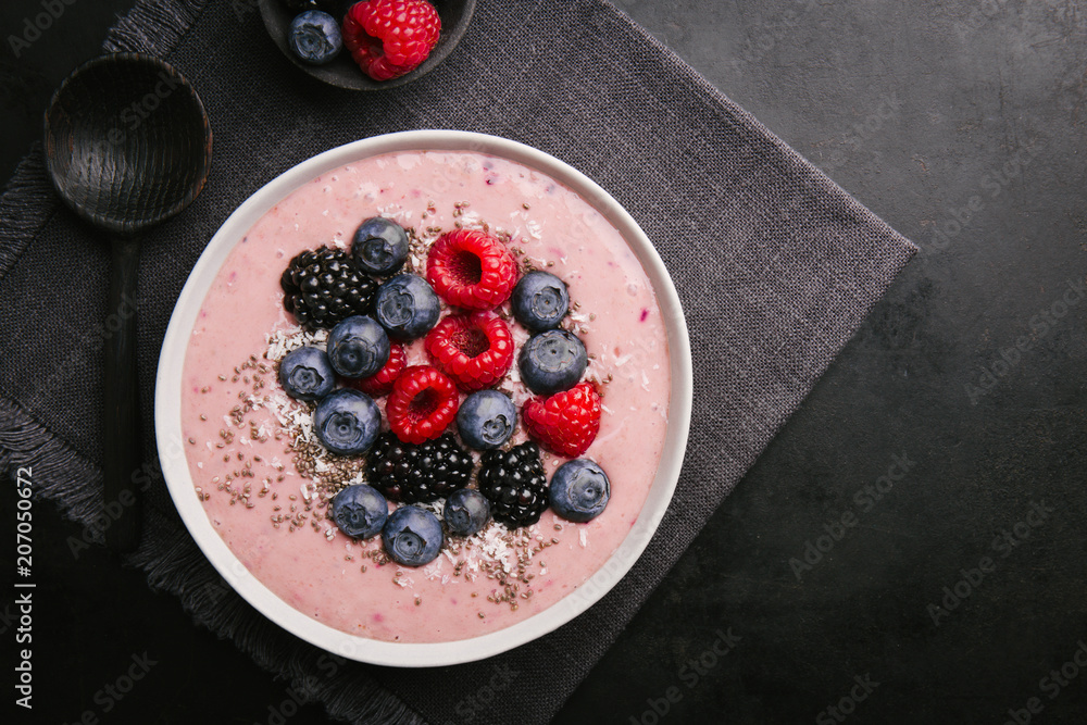 Smoothie bowl on white plate on dark background Smoothie bowl on white plate on dark background