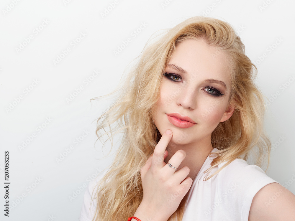 Beauty portrait of model with trendy natural make-up touch chin. Fashion shiny highlighter on skin, sexy gloss lips make-up. Beauty portrait of model with trendy natural make-up touch chin. Fashion shiny highlighter on skin, sexy gloss lips make-up.
