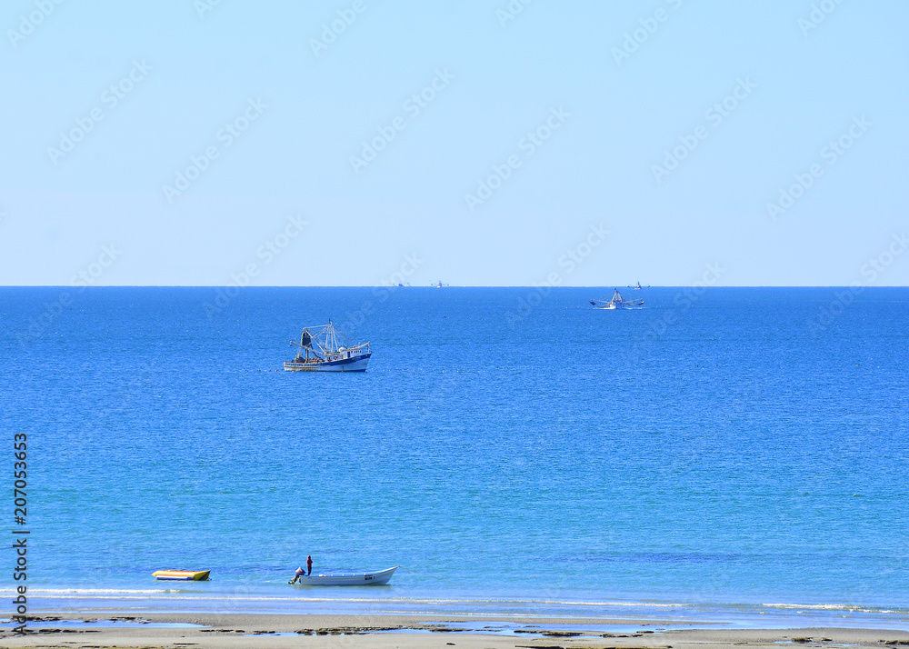Small fishing boat on a beautiful ocean near the beach.