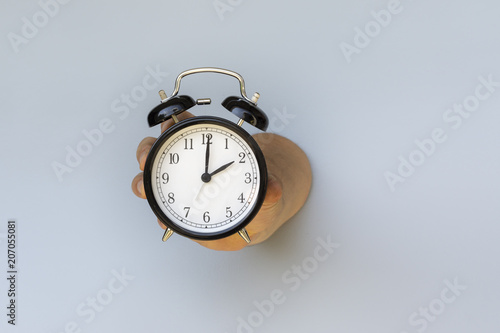 Time is Running Out. Large Classic Alarm Clock in a Hand.