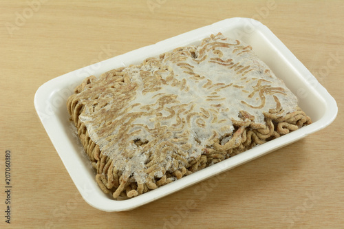 Close up of freezer burned ground beef chuck hamburger meat with frozen ice crystals due to improper storage or packaging before freezing photo