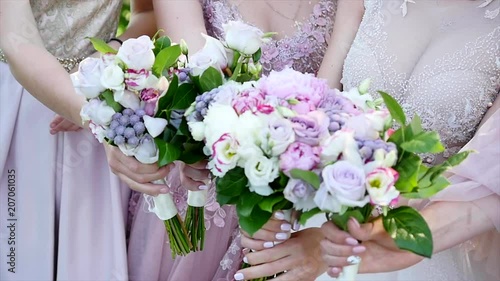 A bride and bridesmaids in violet dresses holding their bouquets. photo