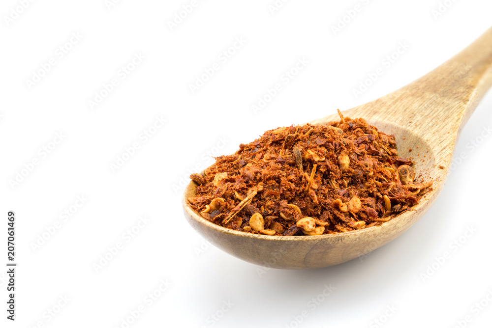Red pepper flakes in wooden spoon on white background Red pepper flakes in wooden spoon on white background