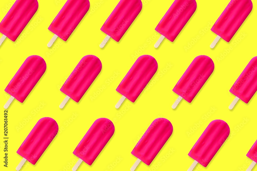 Colorful summer pattern. Bold pink popsicles on a bright yellow background. Top view. Colorful summer pattern. Bold pink popsicles on a bright yellow background. Top view.