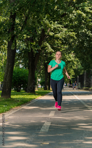 YOUNG WOMAN JOGGING IN THE PARK