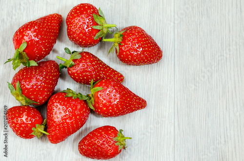 Heap of fresh strawberries on white wooden background