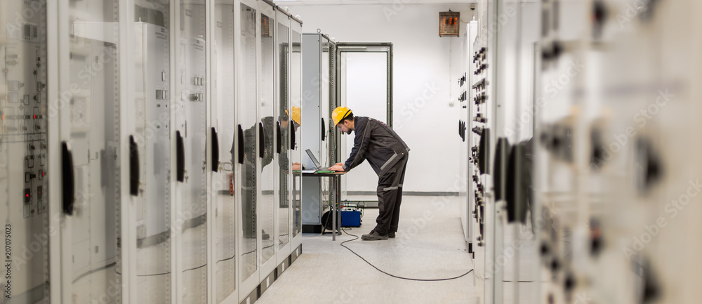 Field service engineer inspect relay protection system with laptop comput Field service engineer inspect relay protection system with laptop comput