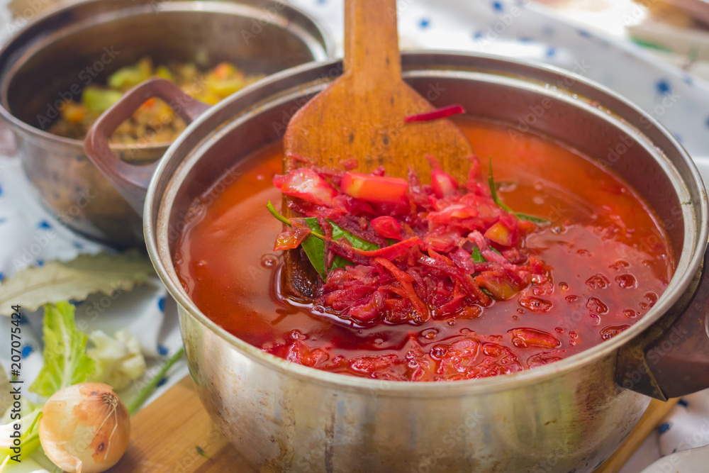 Vegetarian borscht - traditional Russian Ukrainian beetroot cabbage soup cooked in a big family pot with tomatoes and served with buckwheat porridge for lunch or dinner. Vegan healthy food Vegetarian borscht - traditional Russian Ukrainian beetroot cabbage soup cooked in a big family pot with tomatoes and served with buckwheat porridge for lunch or dinner. Vegan healthy food