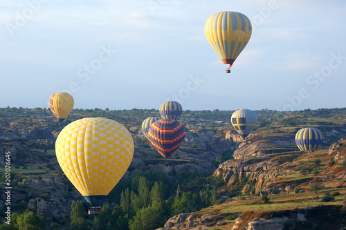 Colorful balloons with people flying in the valley in Cappadocia