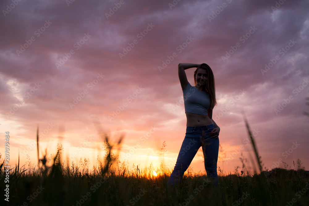 Silhouette of a young woman , sunset sky