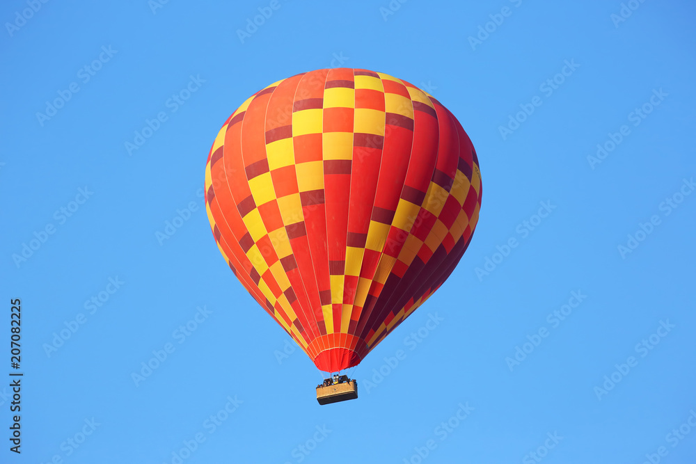 Colored balloon with people flying in the sky in Cappadocia Colored balloon with people flying in the sky in Cappadocia