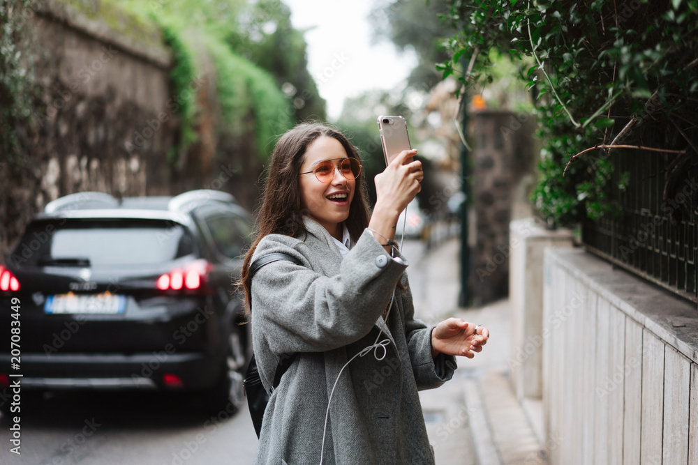 beautiful young girl takes photos on a smartphone beautiful young girl takes photos on a smartphone