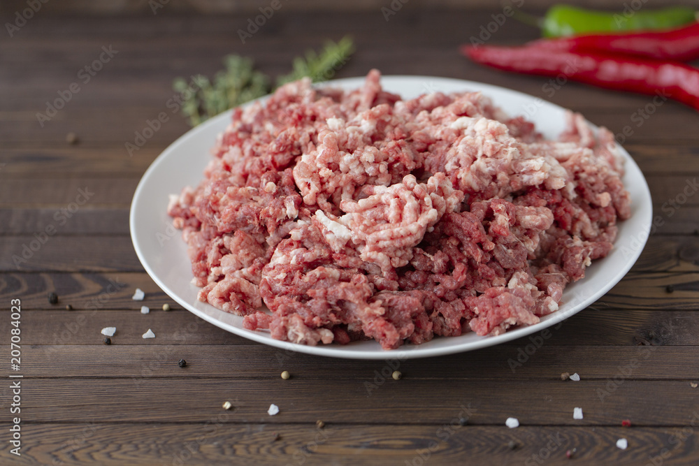 fresh raw minced beef in a plate close up on a rustic wooden table fresh raw minced beef in a plate close up on a rustic wooden table