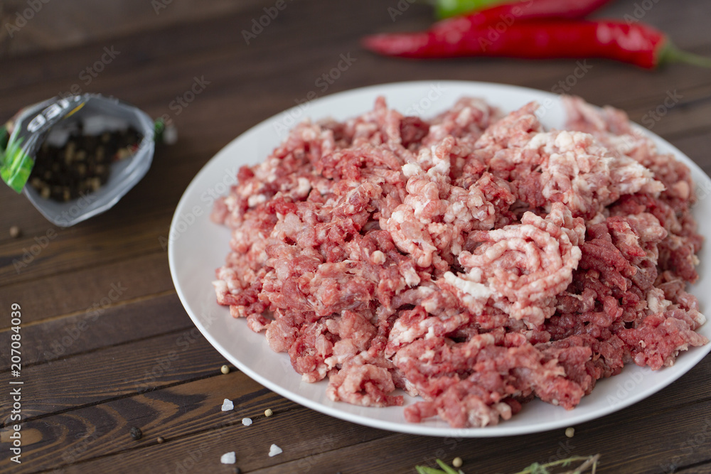 fresh raw minced beef in a plate close up on a rustic wooden table fresh raw minced beef in a plate close up on a rustic wooden table