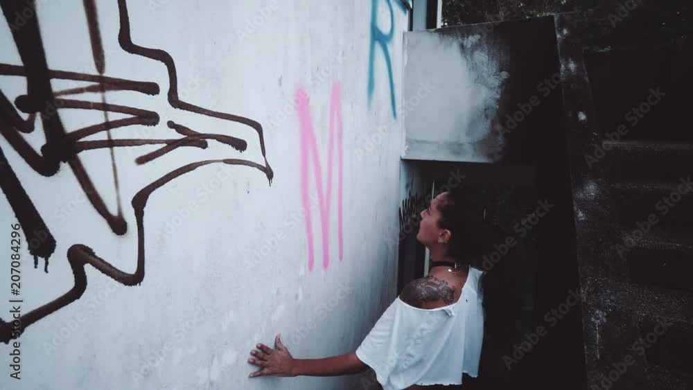 Vidéo Stock Graffiti artist girl painting on the wall of abandoned ...