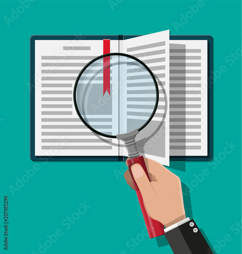 Open book and hand with magnifying glass