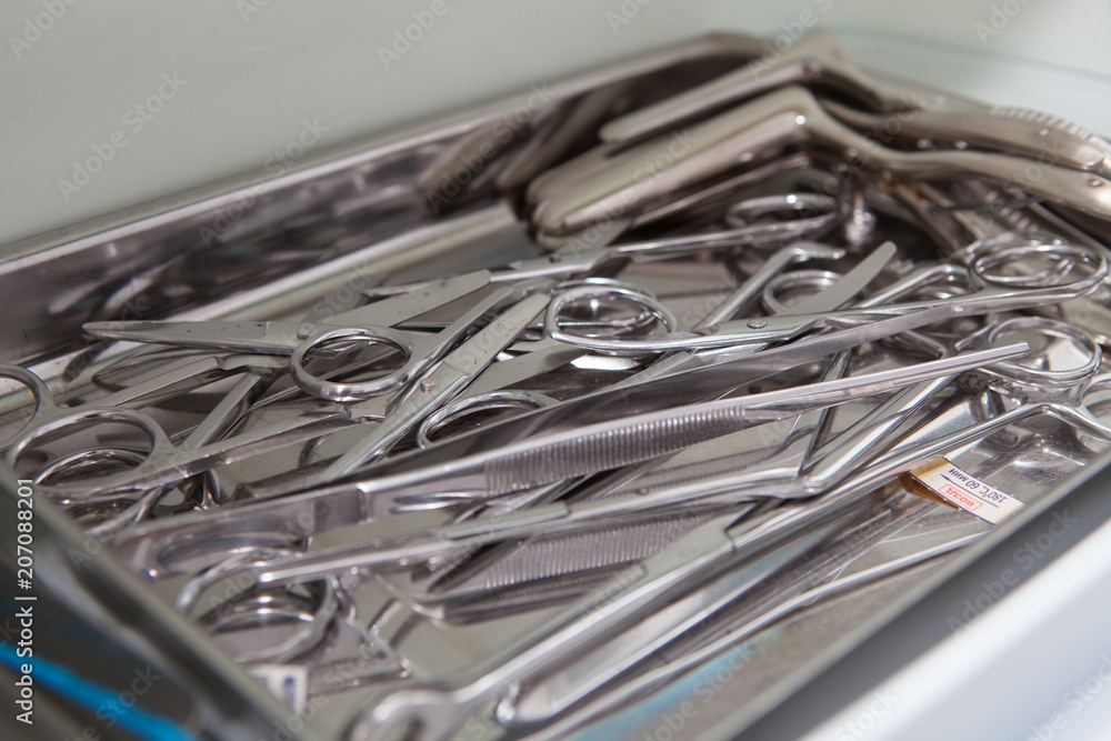 Medical scissors, tweezers and other tools in a stainless steel tray Medical scissors, tweezers and other tools in a stainless steel tray