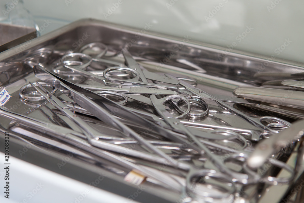 Medical scissors, tweezers and other tools in a stainless steel tray Medical scissors, tweezers and other tools in a stainless steel tray