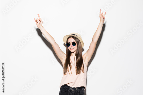 Stylish fashion girl in a black t-shirt and rock sunglasses rocky emotional woman giving the Rock and Roll sign, devil horns gesture isolated on white