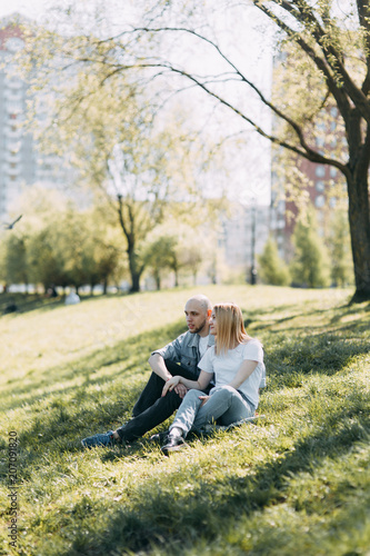 Beautiful young couple in the Park on a Sunny day, loving and happy. Walk and laugh with the dog. Pre-wedding shooting in nature. Casual style in clothing and European in processing © pavelvozmischev