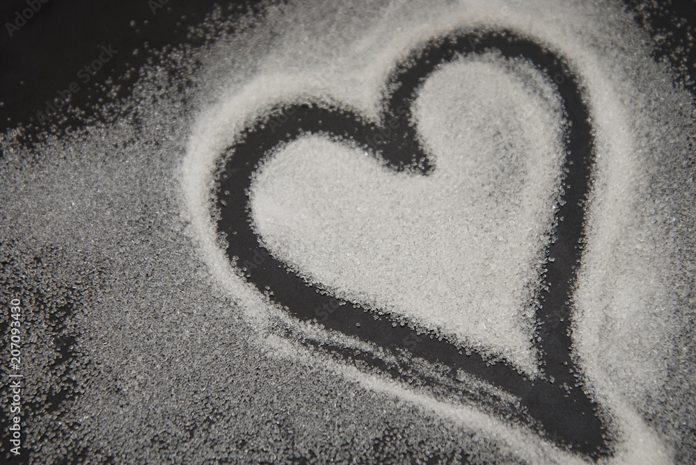 Fototapeta premium Spilled Sugar Heart Love Shape of Heart Black Background. unhealthy sugar. Love sugar Sweet.