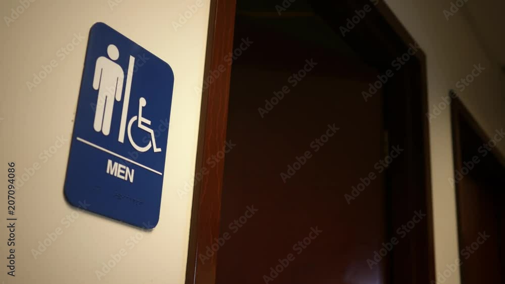 Man exits a bathroom in an office building Man exits a bathroom in an office building