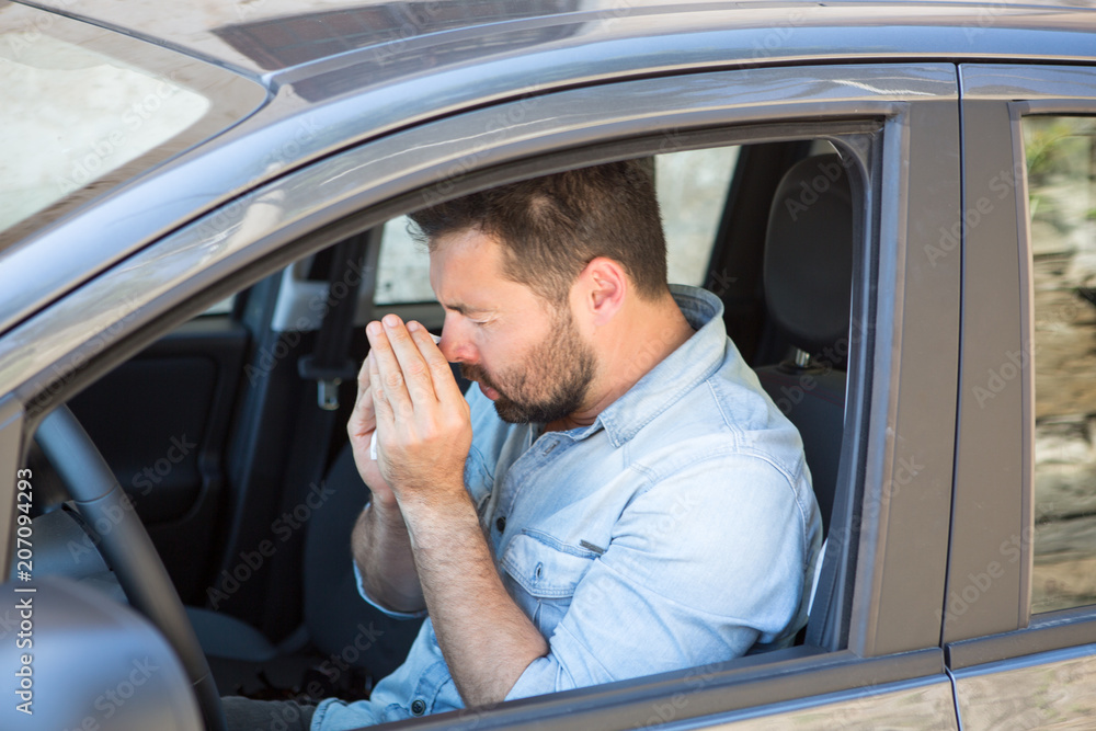 Man reacts with pollen on hay fever in a car Man reacts with pollen on hay fever in a car