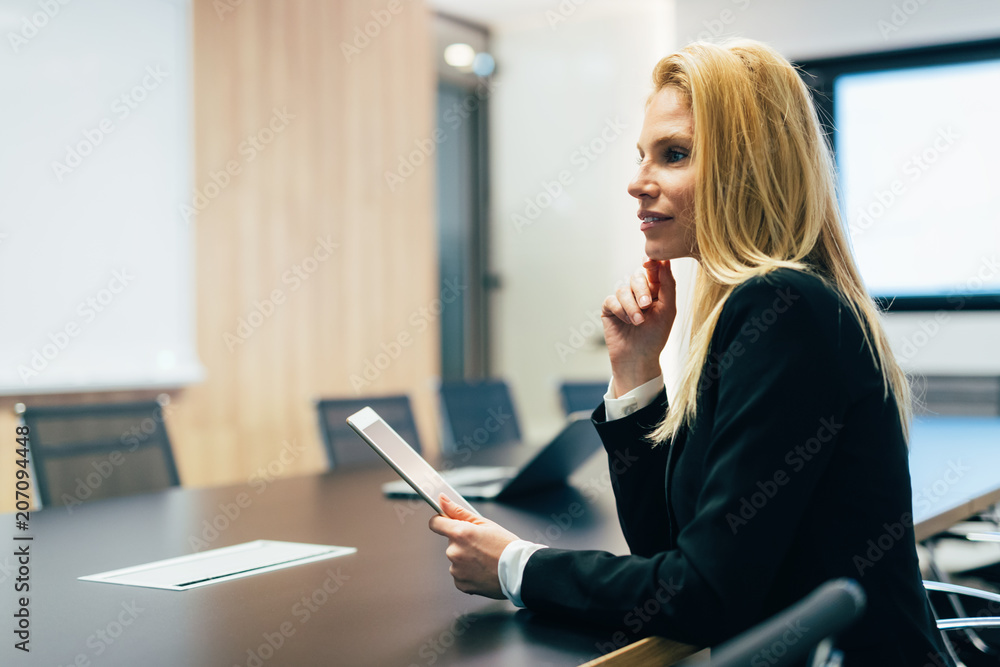 Attractive businesswoman using digital tablet in office Attractive businesswoman using digital tablet in office