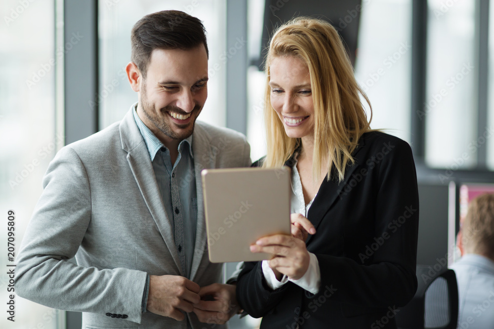 Businesspeople discussing while using digital tablet in office Businesspeople discussing while using digital tablet in office