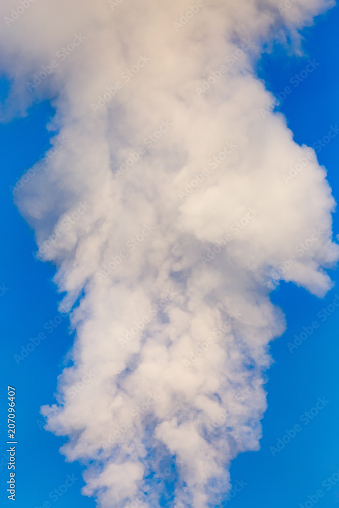 smoke from a pipe in the factory against a blue sky