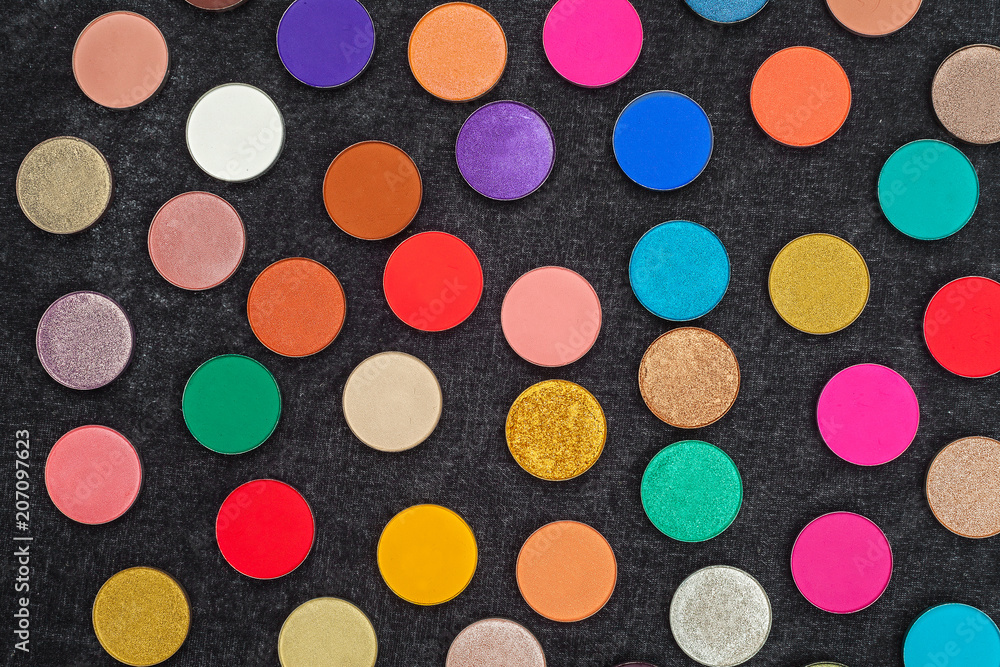 set of lots of shimmer and matt multicolored circle shaped eye shadows lying on a black background. concept of professional make up tools set of lots of shimmer and matt multicolored circle shaped eye shadows lying on a black background. concept of professional make up tools