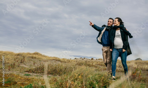Young couple embraced taking a walk near the coast