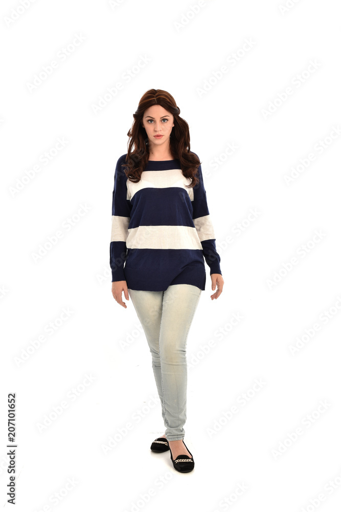 full length portrait of girl wearing striped blue and white jumper and jeans. standing pose on white studio background full length portrait of girl wearing striped blue and white jumper and jeans. standing pose on white studio background