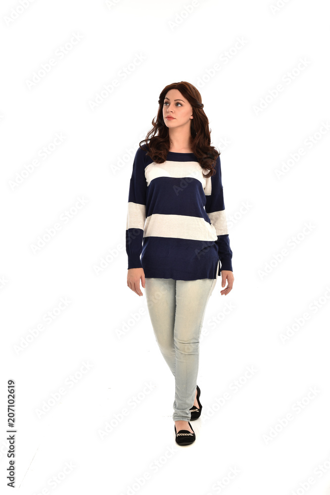 full length portrait of girl wearing striped blue and white jumper and jeans. standing pose on white studio background full length portrait of girl wearing striped blue and white jumper and jeans. standing pose on white studio background