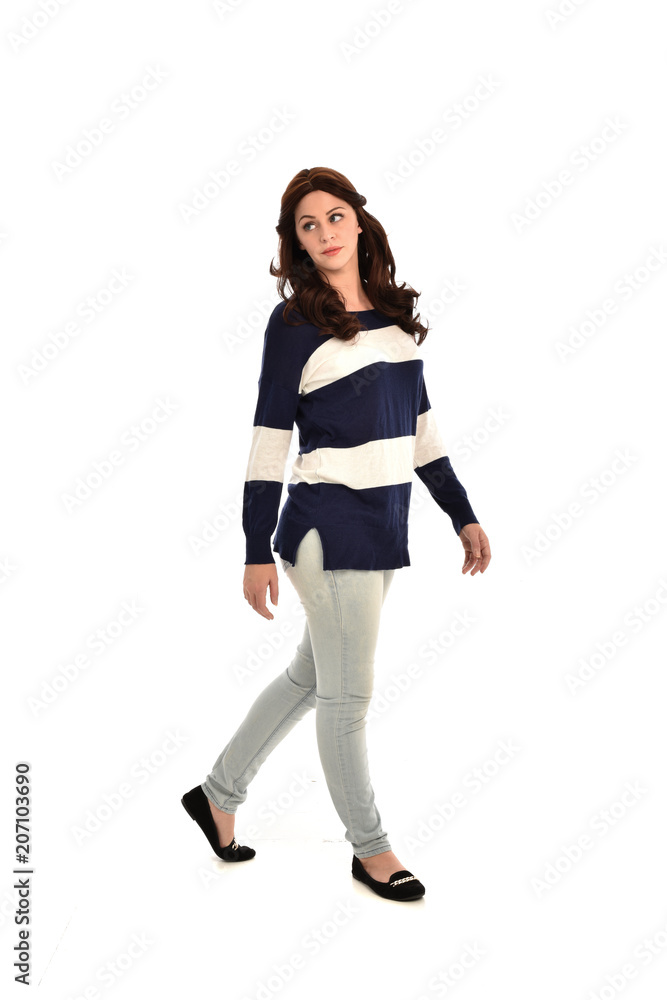 full length portrait of girl wearing striped blue and white jumper and jeans. standing pose on white studio background full length portrait of girl wearing striped blue and white jumper and jeans. standing pose on white studio background