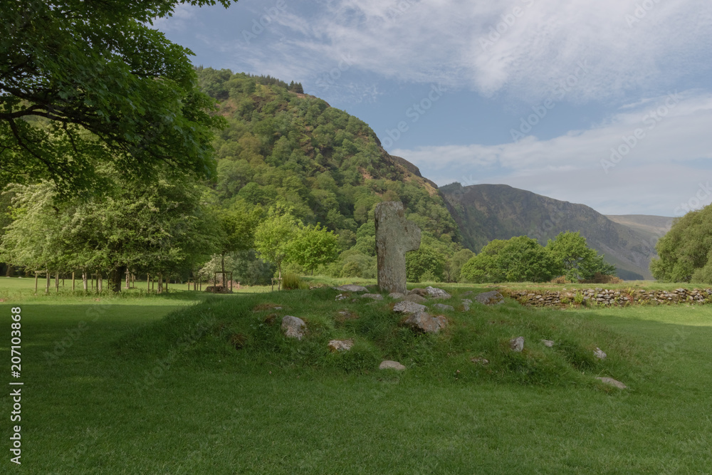 Celtic cross, grave hill, against beautiful mountain range, tranquil peaceful scene
