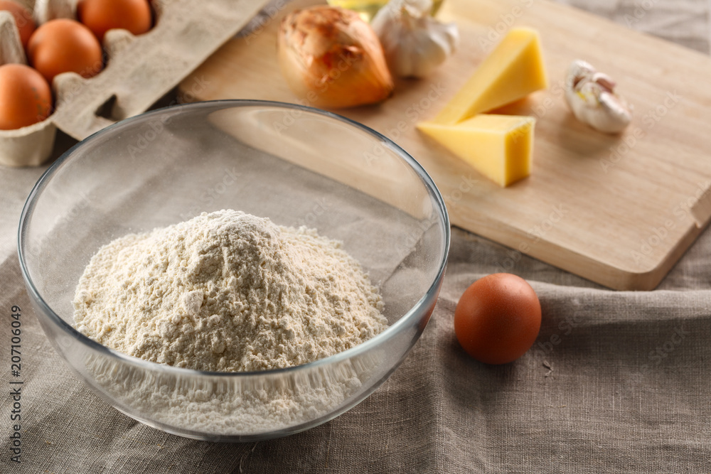 flour in a glass Cup on the background of other ingredients for dough