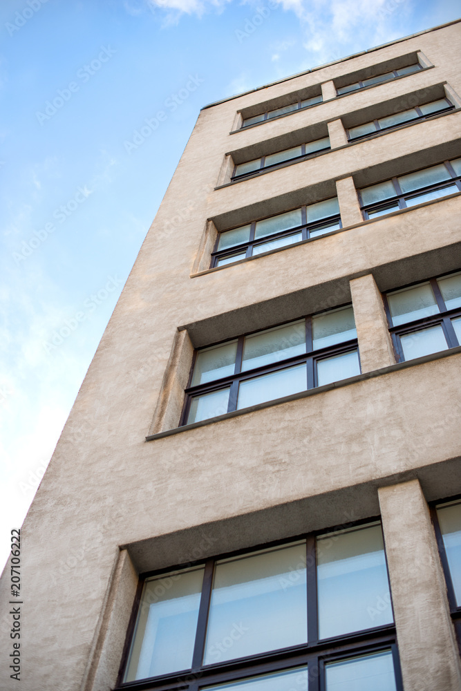 Fragment of a gray high-rise building built in the 1930s of the 19th century, view from below Fragment of a gray high-rise building built in the 1930s of the 19th century, view from below