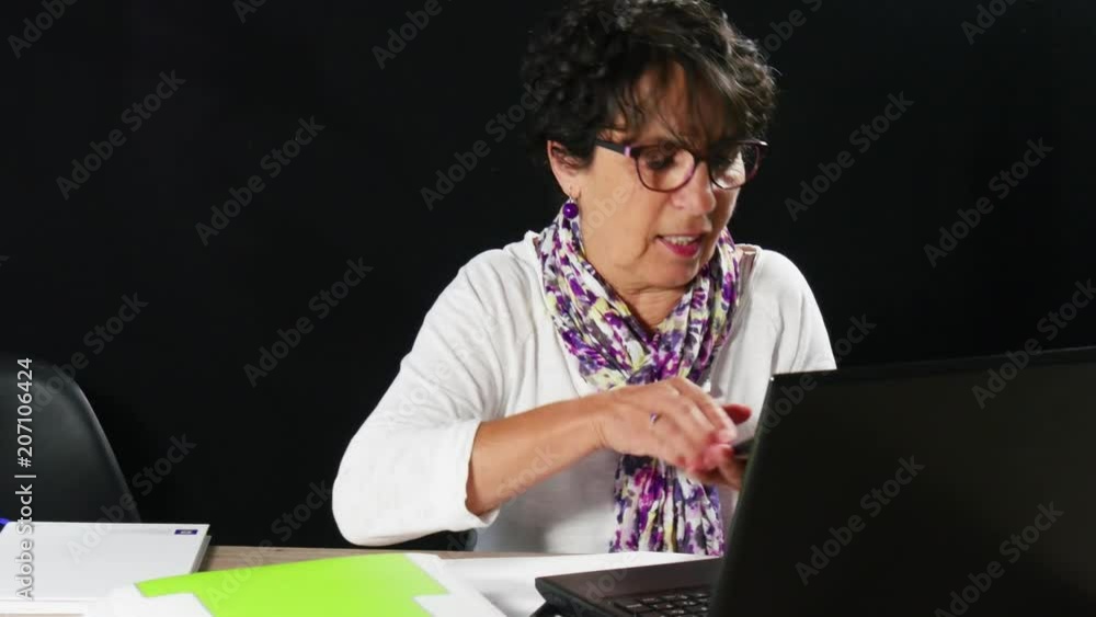 beautiful mature woman using laptop and answers the phone beautiful mature woman using laptop and answers the phone