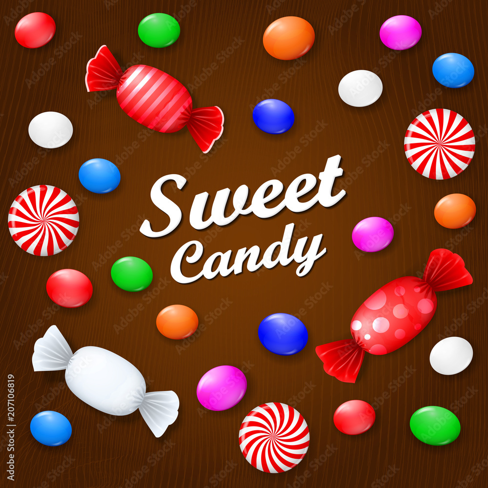 Colored candies, sweets and lollipops. On a brown wooden background. View from above.