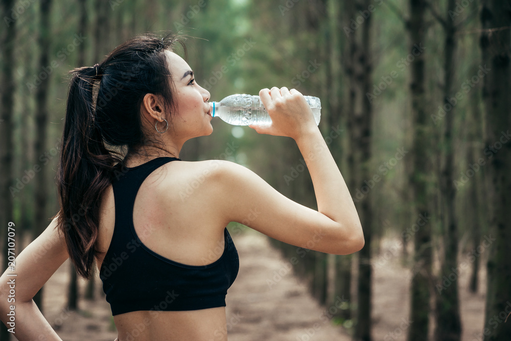 Asian girl is exercising at the weekend in a pine forest green and lush beautiful. Sport girl and lifestyle concept. She also playing yoga. Asian girl is exercising at the weekend in a pine forest green and lush beautiful. Sport girl and lifestyle concept. She also playing yoga.