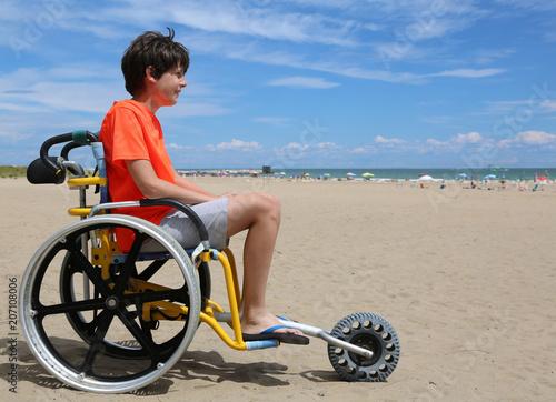 boy looks at the sea from a wheelchair photo