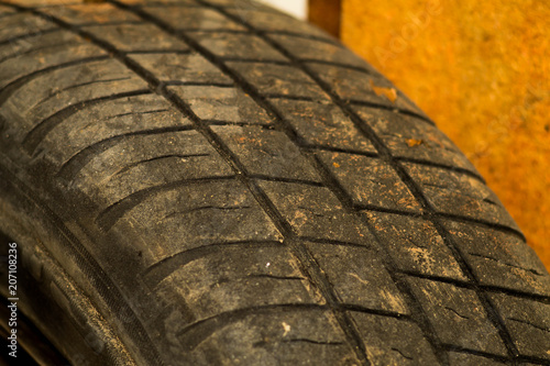 Old car tire tread texture background. Worn out protector of car tire. Used wheels close up. photo