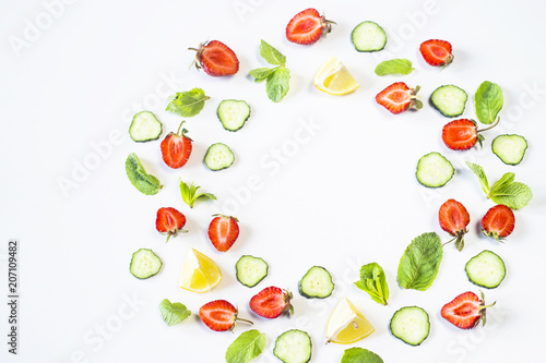 Fototapeta Naklejka Na Ścianę i Meble -  Strawberries, lemon, cucumber and mint are lined in the form of a wreath on a white background. Detox Concept. Top view, flat lay