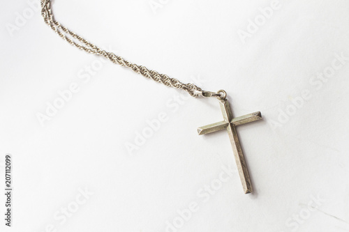 Silver cross with chain on white background