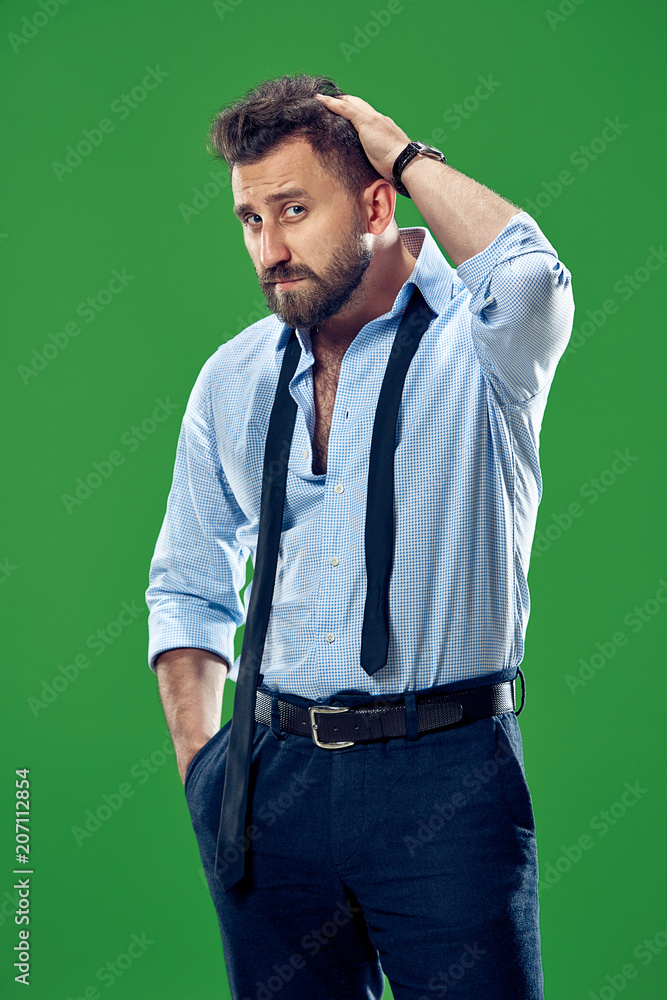 Male beauty concept. Portrait of a fashionable young man with stylish haircut wearing trendy suit posing over red background. Male beauty concept. Portrait of a fashionable young man with stylish haircut wearing trendy suit posing over red background.