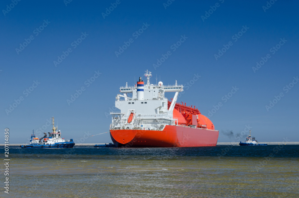 LNG TANKER - The red ship enters port with assurance of tugs