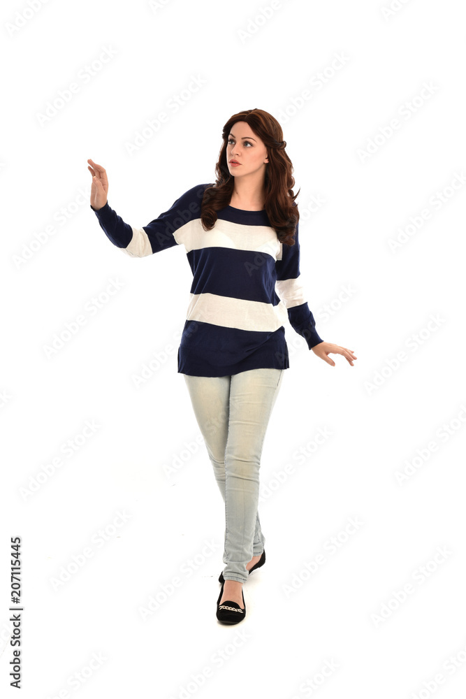 full length portrait of girl wearing striped blue and white jumper and jeans. standing pose on white studio background full length portrait of girl wearing striped blue and white jumper and jeans. standing pose on white studio background